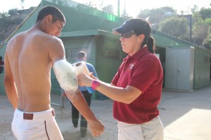 ICING IT UP: Athletic trainer Claudia Alvarez wraps the arm of Vaquero’s star pitcher Angel Rodriguez after Rodriguez pitched all nine innings against L.A. Mission College.
